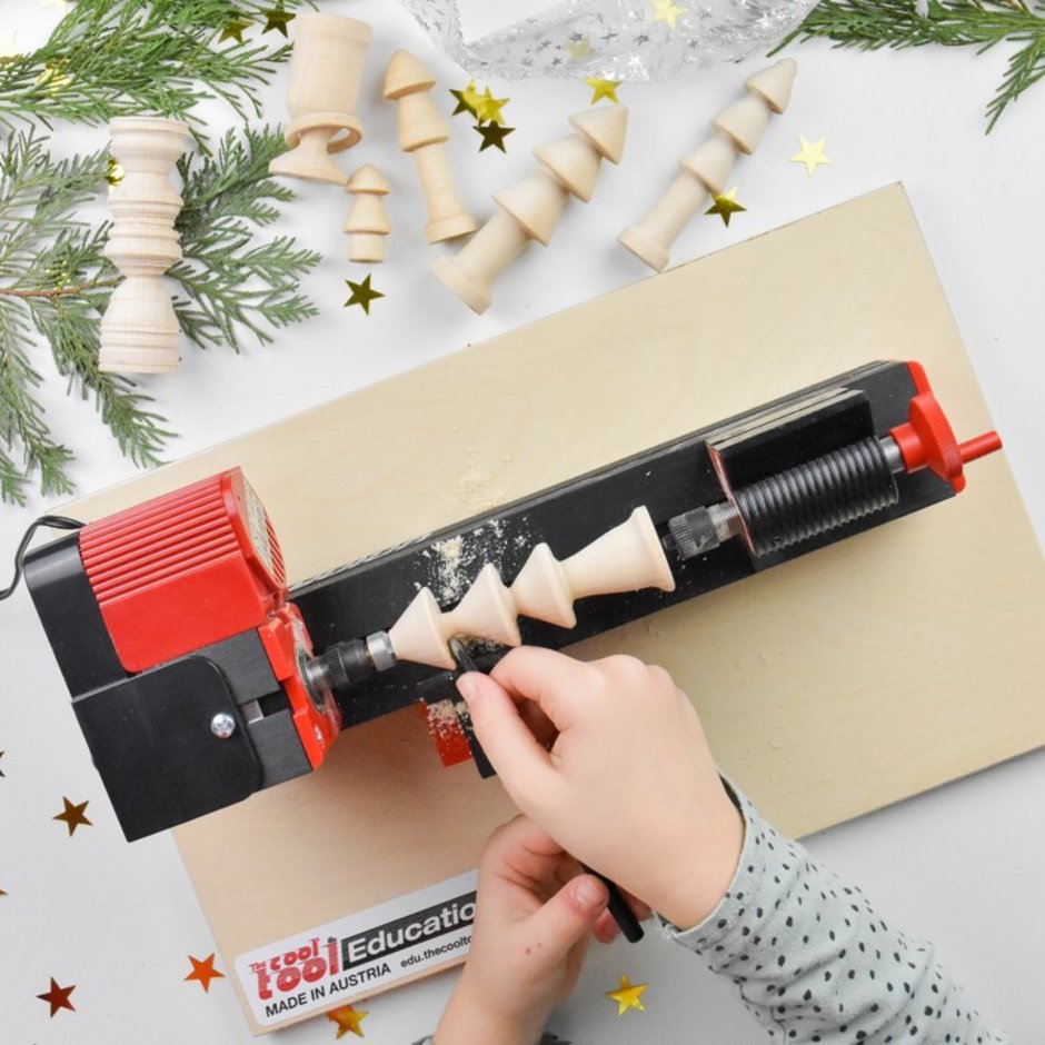 Kind arbeitet mit der UNIMAT 1 Drechselbank und bastelt Weihnachtsbäume aus Holz