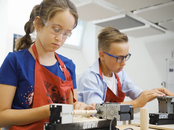 Workshop mit UNIMAT Design und Werkerziehung Drechselbank 2 Jugendliche beim Arbeiten an der Drechselbank